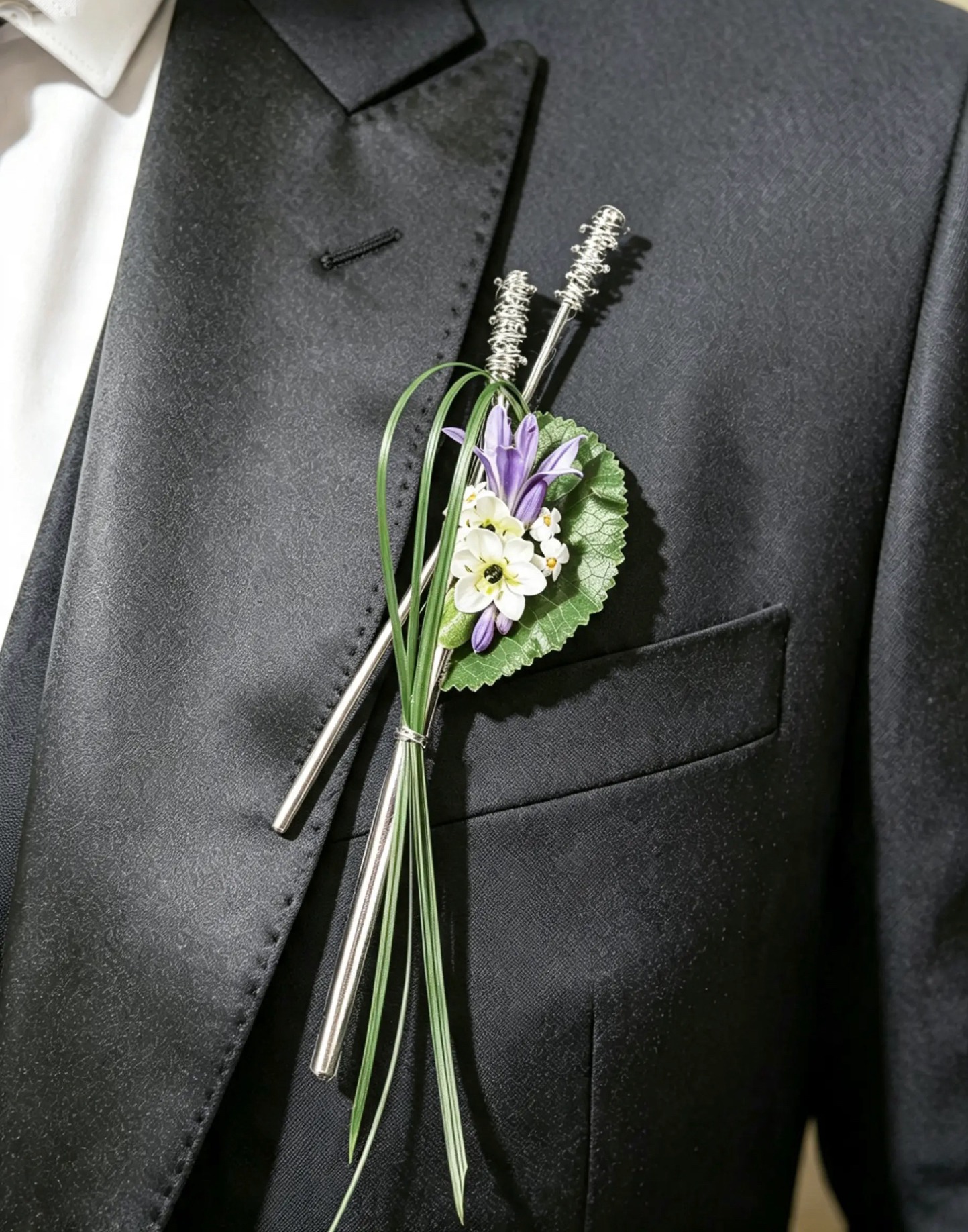Moderner Anstecker mit weißen und violetten Blüten, Gräsern und Silberstäben