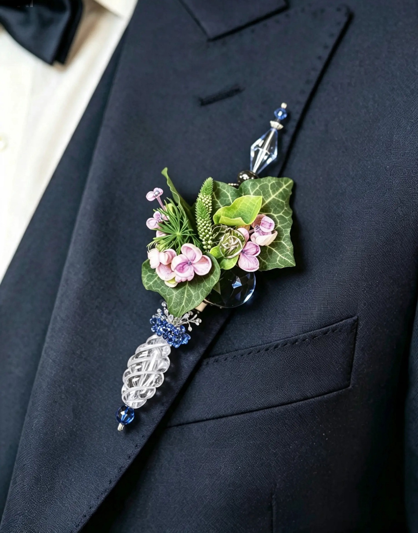 Floraler Bräutigam-Anstecker mit Efeu, rosa Blüten und Glasornamenten