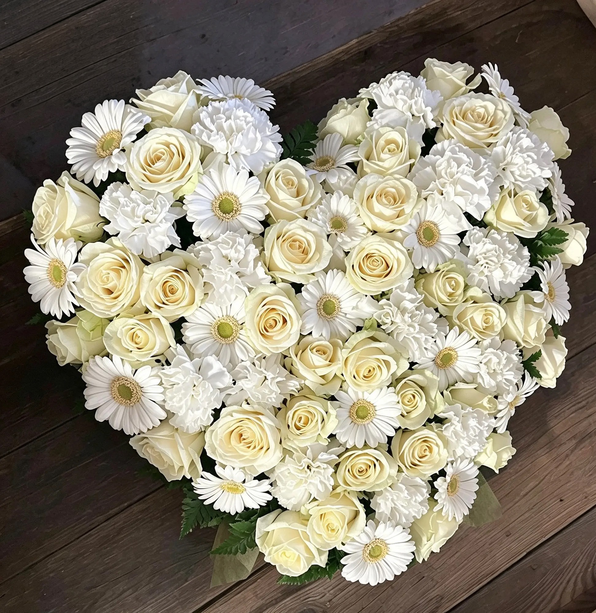 Geschlossenes Herz aus weißen Rosen, Gerbera und Nelken