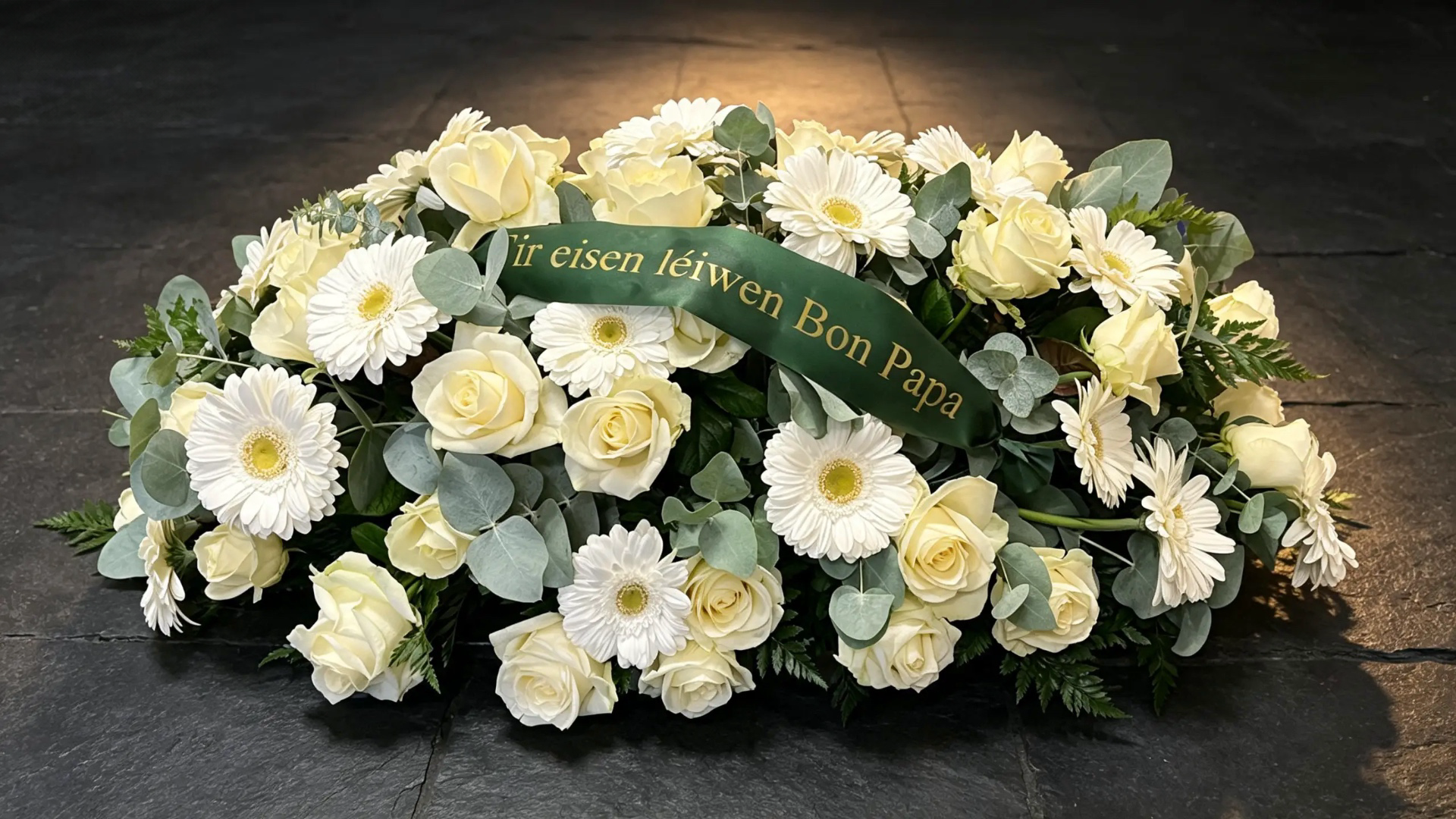 Trauergebinde in Cremeweiß mit Rosen, Gerbera, Eukalyptus und Schleife